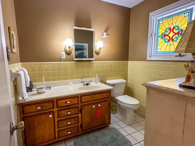 bathroom featuring toilet, tile walls, vanity, and tile patterned floors