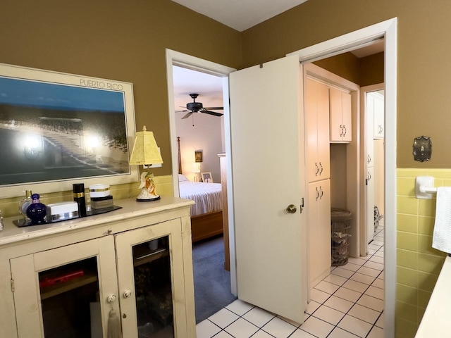 hallway featuring light tile patterned flooring and tile walls