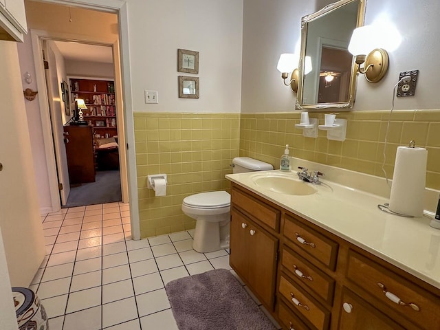 bathroom with vanity, tile patterned flooring, toilet, and tile walls