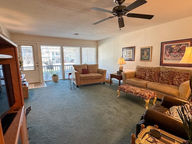 carpeted living room featuring a textured ceiling and ceiling fan