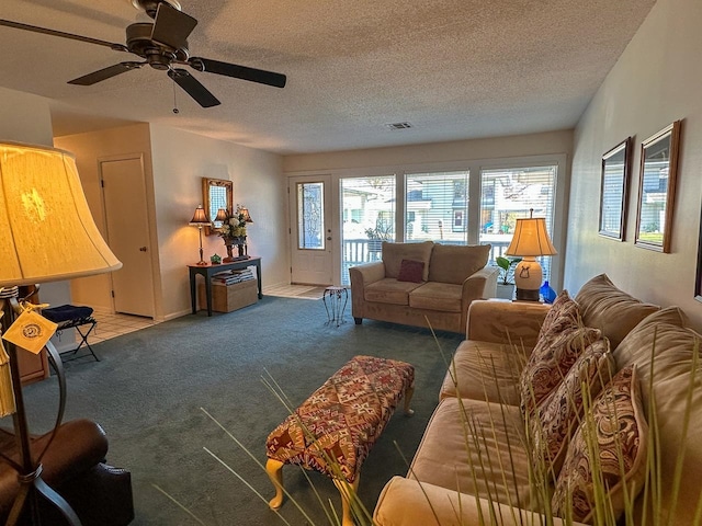 carpeted living room featuring a textured ceiling and ceiling fan