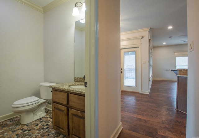 bathroom with hardwood / wood-style floors, plenty of natural light, ornamental molding, and vanity