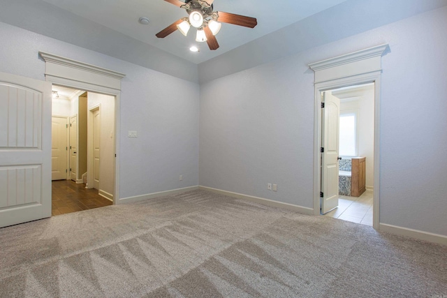 carpeted spare room featuring ceiling fan