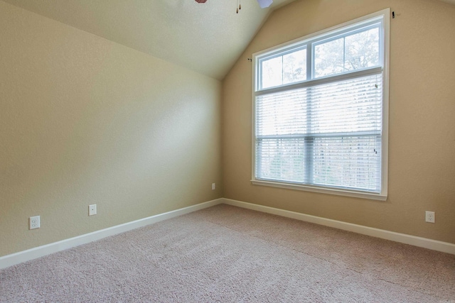 carpeted spare room featuring ceiling fan, a textured ceiling, and vaulted ceiling