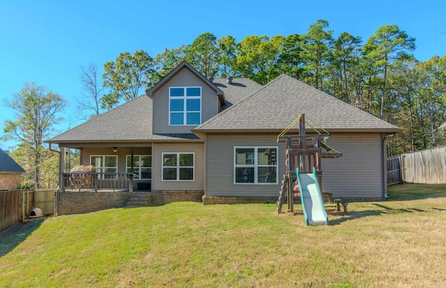 back of property with a playground and a lawn