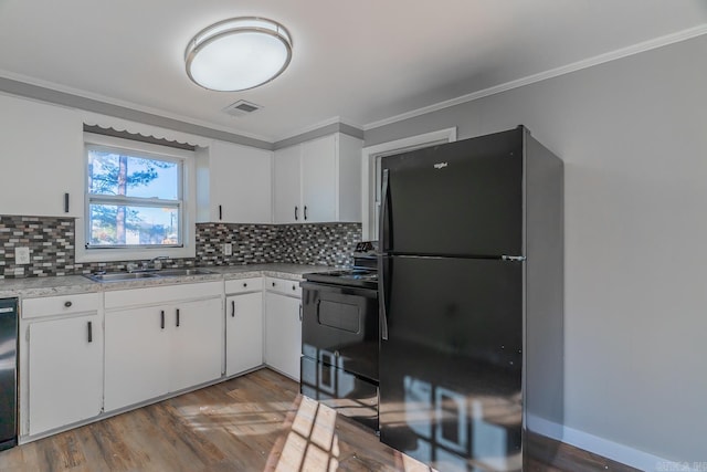 kitchen with white cabinets, black appliances, and tasteful backsplash