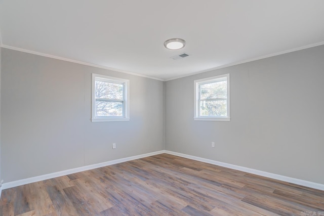 spare room featuring hardwood / wood-style floors, ornamental molding, and plenty of natural light