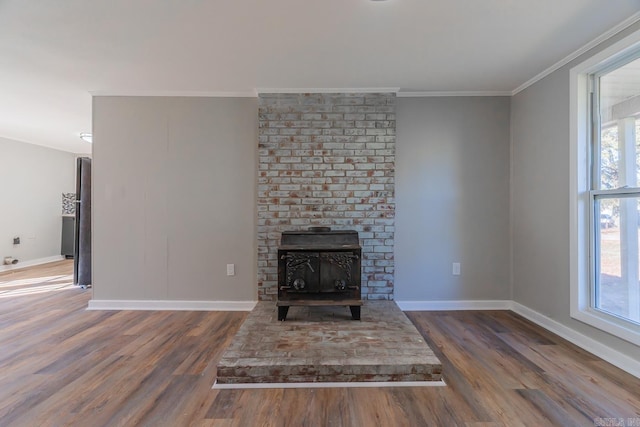 unfurnished living room featuring a wood stove, dark wood-type flooring, and ornamental molding