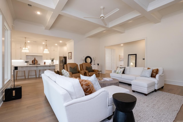 living room with light hardwood / wood-style floors, ceiling fan, beam ceiling, and coffered ceiling