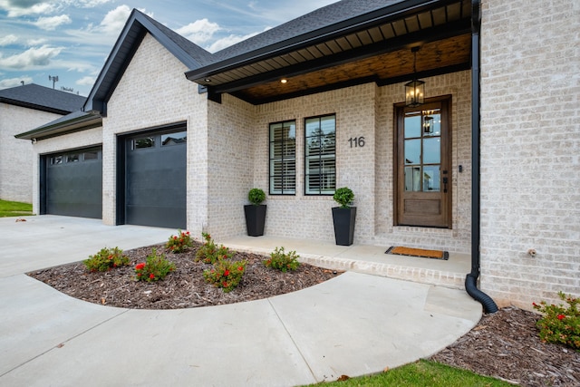 doorway to property with a garage and a porch