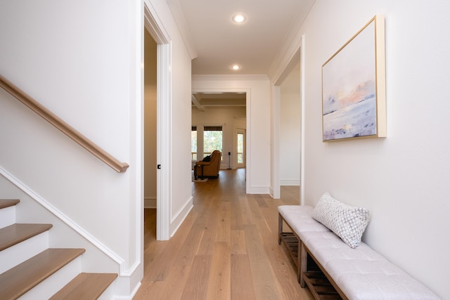 hallway with light hardwood / wood-style flooring and crown molding