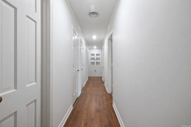 hallway with ornamental molding and dark wood-type flooring