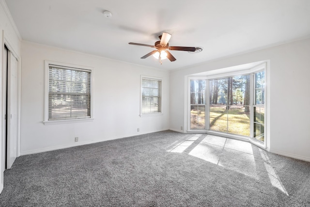 spare room with carpet, ornamental molding, and plenty of natural light