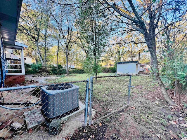 view of yard featuring a storage unit and central air condition unit