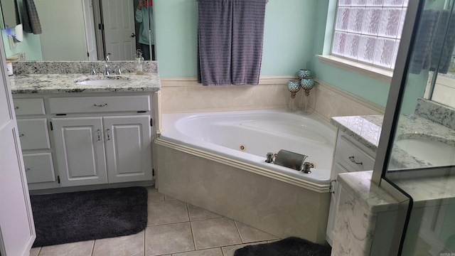 bathroom with tile patterned floors, vanity, and a relaxing tiled tub