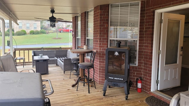 wooden deck with ceiling fan and an outdoor living space