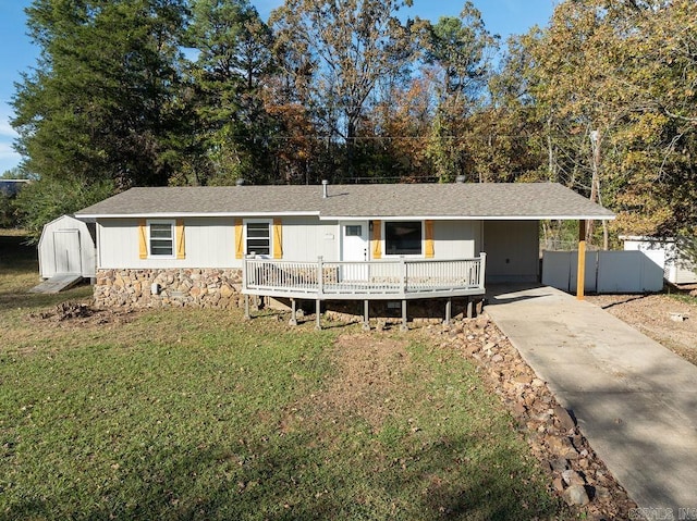 ranch-style house with a front yard, a storage unit, a wooden deck, and a carport