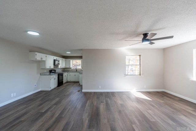 unfurnished living room featuring sink, ceiling fan, a textured ceiling, and dark hardwood / wood-style floors