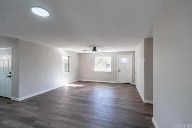 foyer with dark wood-type flooring, a textured ceiling, and ceiling fan