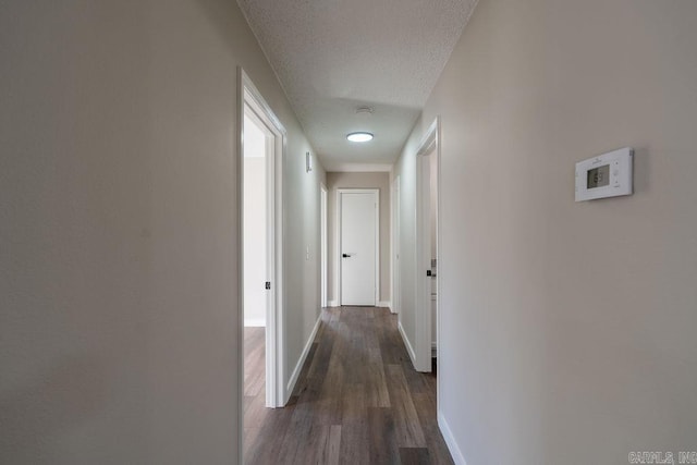 corridor featuring a textured ceiling and dark hardwood / wood-style floors