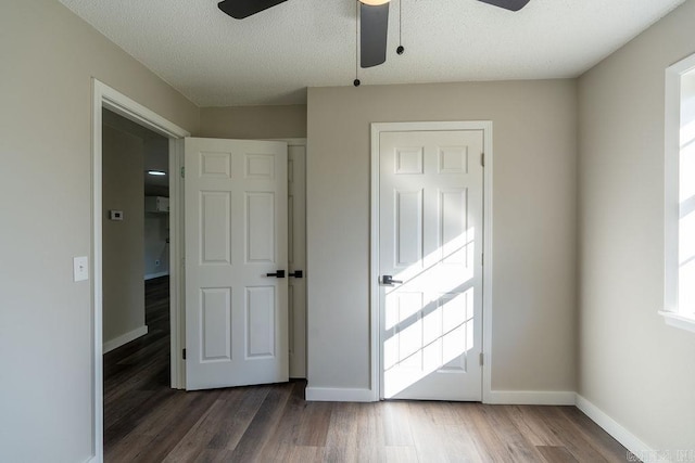 interior space with ceiling fan, a textured ceiling, and dark hardwood / wood-style floors