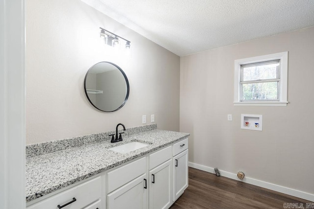 bathroom with hardwood / wood-style floors, vanity, and a textured ceiling