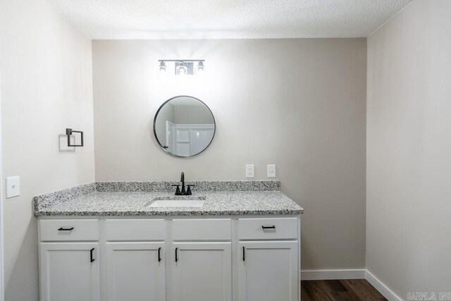 bathroom with vanity, wood-type flooring, and a textured ceiling