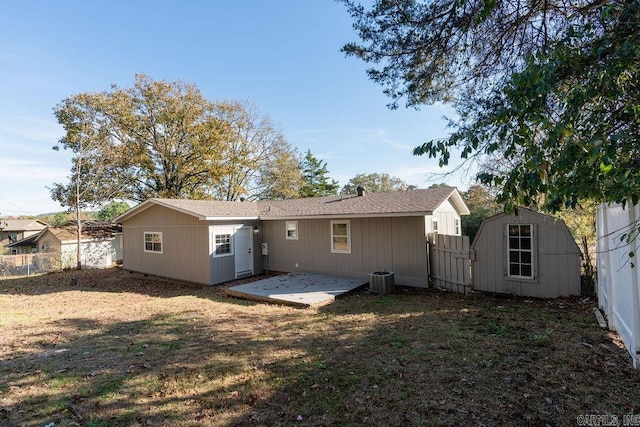 rear view of house featuring cooling unit, a storage unit, a patio, and a yard