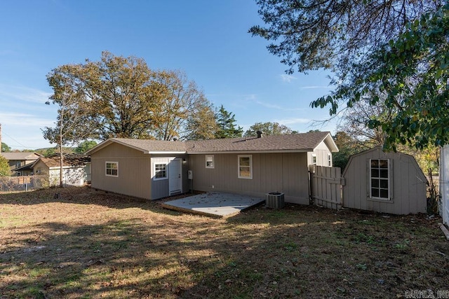 back of property with a shed, a patio, a lawn, and cooling unit