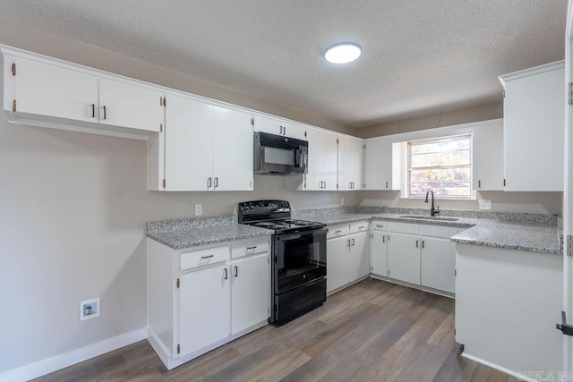 kitchen featuring black appliances, wood-type flooring, white cabinetry, a textured ceiling, and sink