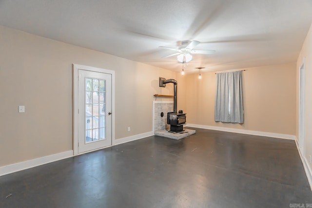 exercise room featuring a wood stove and ceiling fan