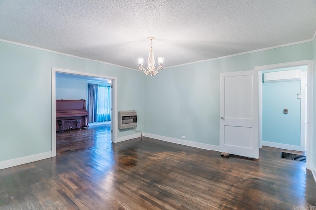 spare room featuring a textured ceiling, an inviting chandelier, dark hardwood / wood-style floors, and heating unit