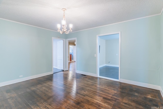 empty room featuring ornamental molding, dark wood-type flooring, a textured ceiling, and a notable chandelier