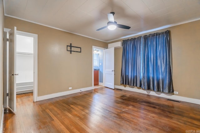 unfurnished room featuring hardwood / wood-style floors, ceiling fan, and crown molding