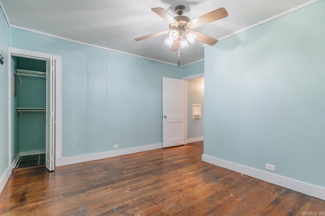 unfurnished bedroom with ornamental molding, dark wood-type flooring, ceiling fan, and a closet