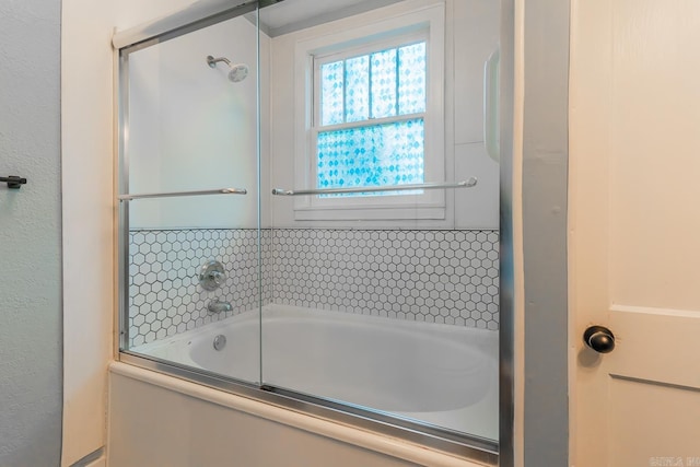 bathroom with bath / shower combo with glass door