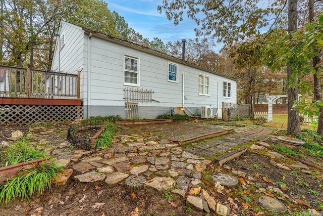 back of property with a wooden deck and ac unit