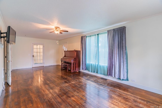 interior space with ceiling fan, a textured ceiling, dark hardwood / wood-style flooring, and crown molding