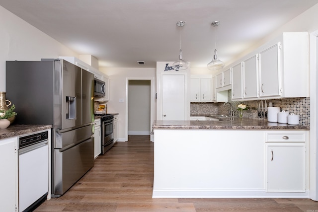 kitchen with stainless steel appliances, sink, light hardwood / wood-style flooring, white cabinets, and decorative backsplash