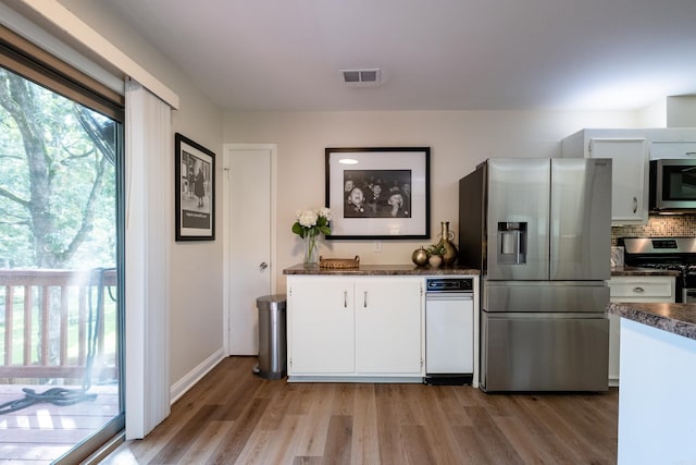 kitchen featuring light wood-type flooring, tasteful backsplash, white cabinetry, and stainless steel appliances