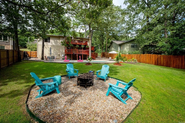 view of yard featuring a deck, a fire pit, and a patio area