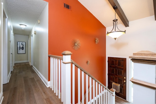 interior space featuring hardwood / wood-style floors, beamed ceiling, a textured ceiling, and high vaulted ceiling