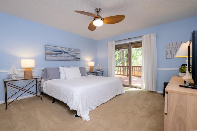 bedroom with ceiling fan, access to exterior, a textured ceiling, and light colored carpet