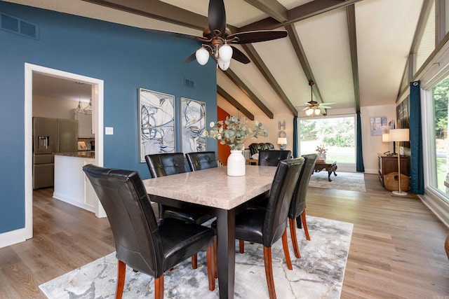 dining area with beamed ceiling, a wealth of natural light, ceiling fan, and light hardwood / wood-style flooring