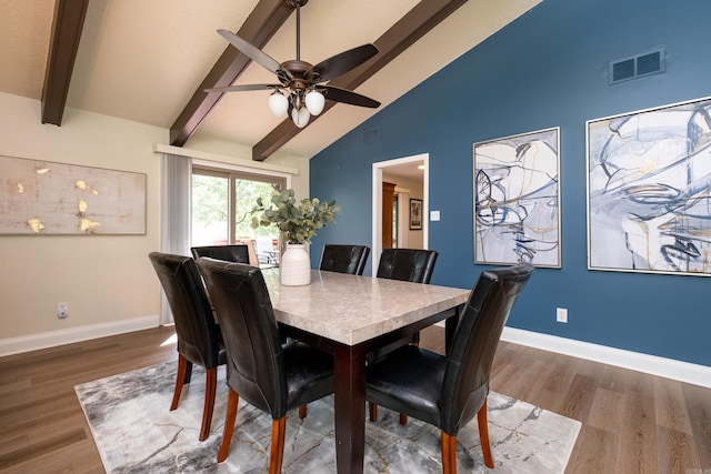 dining room featuring ceiling fan, vaulted ceiling with beams, and dark hardwood / wood-style floors