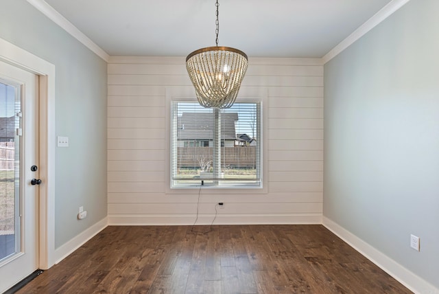 unfurnished dining area with dark hardwood / wood-style floors, wooden walls, and crown molding