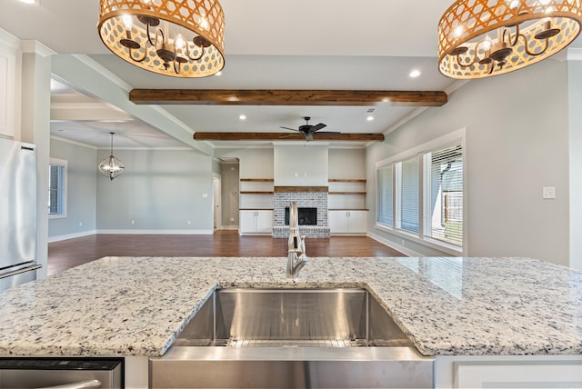 kitchen with a fireplace, beam ceiling, light stone countertops, pendant lighting, and dark wood-type flooring