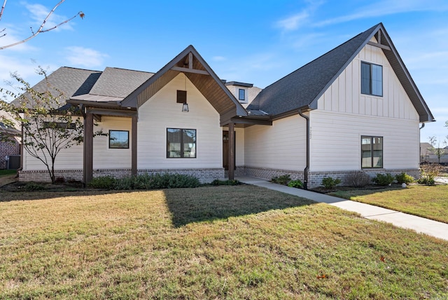 view of front of house with a front lawn and central AC