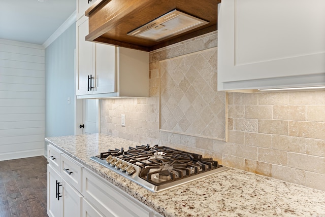 kitchen with stainless steel gas cooktop, custom range hood, dark hardwood / wood-style floors, light stone countertops, and white cabinets