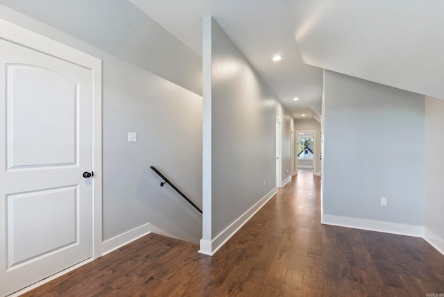 hallway featuring dark wood-type flooring and vaulted ceiling